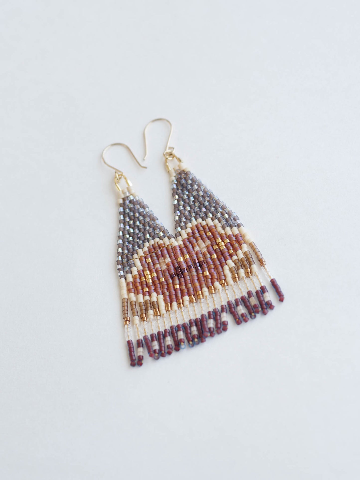 Beaded earrings with a geometric pattern on a light gray background