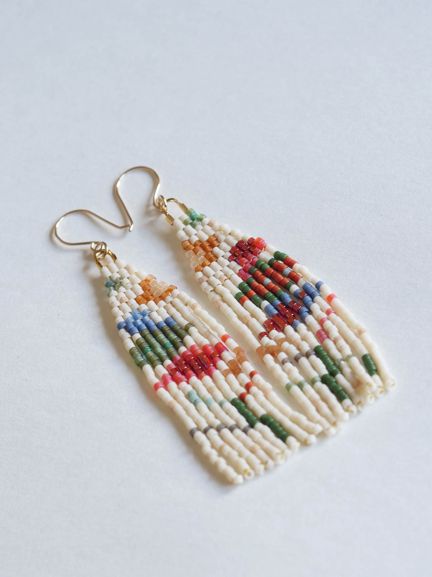 Colorful beaded earrings on a light gray background